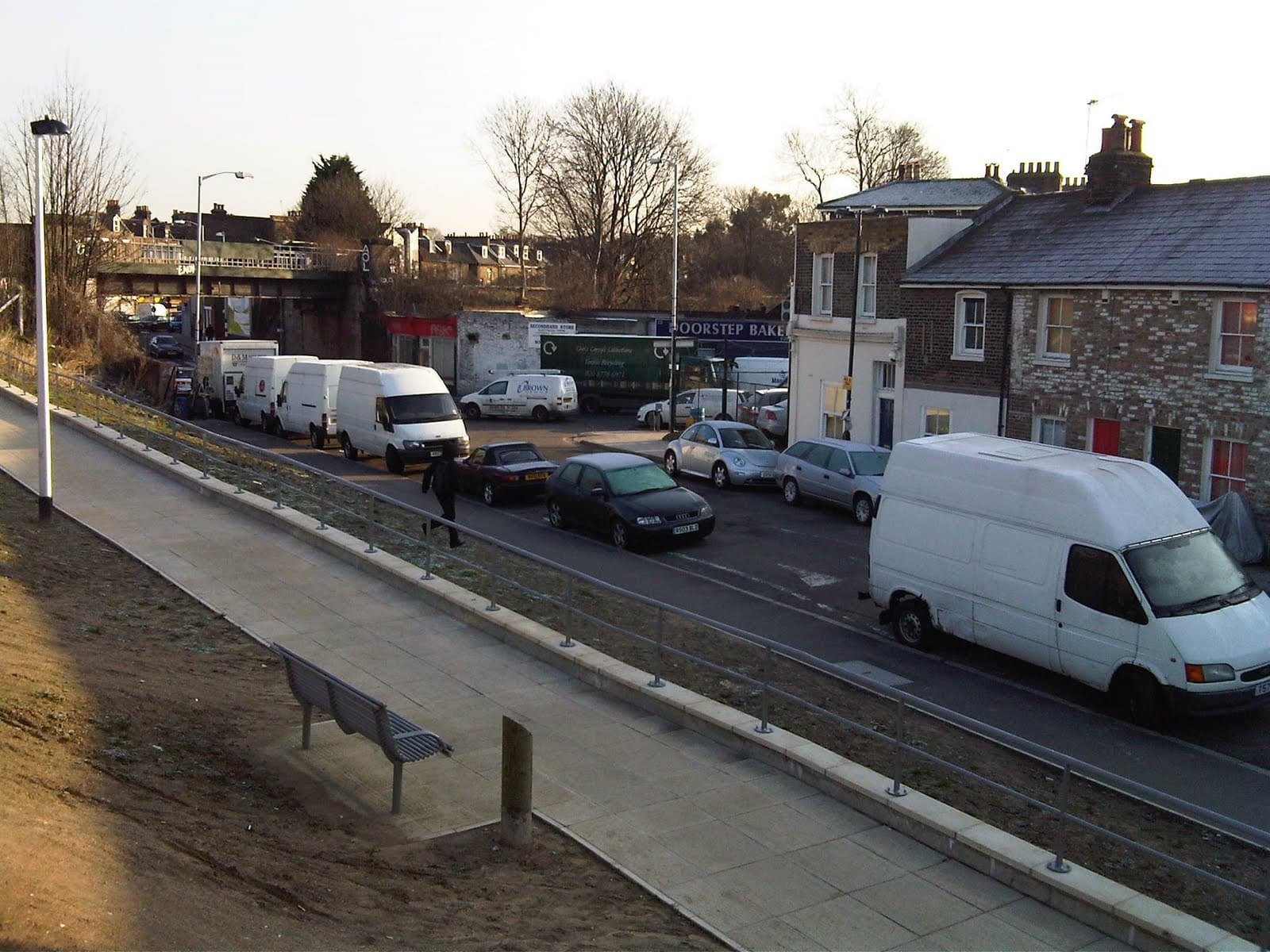 Vans and cars parked nose to tail along Coulgate Street beside the newly built steps and ramp to Brockley station
