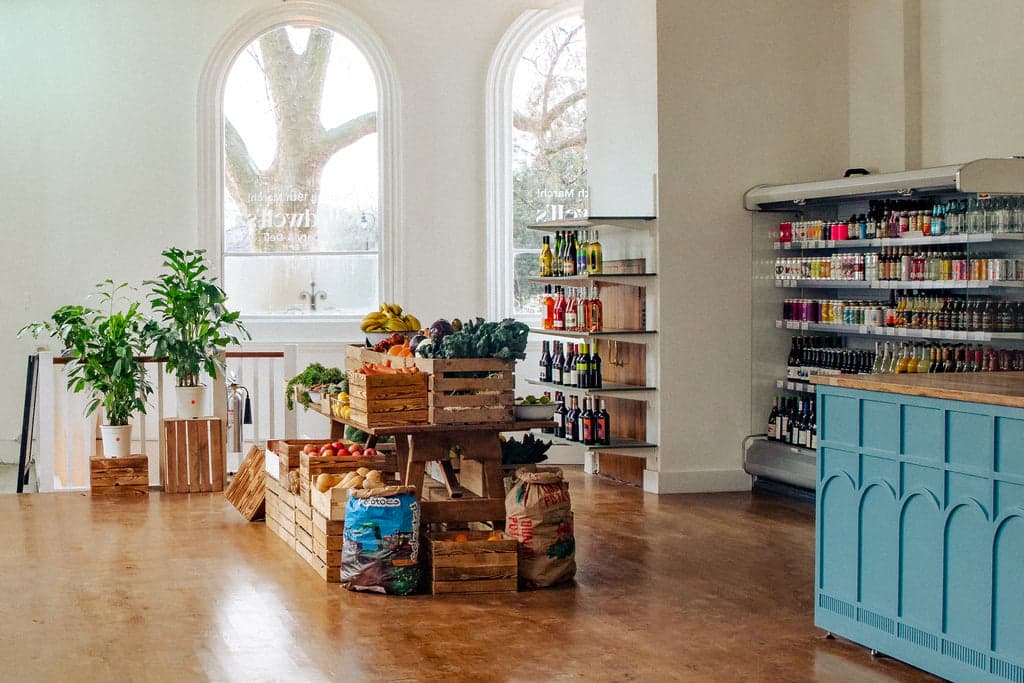 The interior of Gladwell's grocery and deli in Camberwell, with produce displayed in wooden crates and refrigerated shelves along the wall