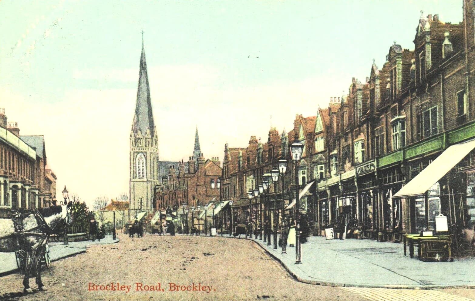 A coloured postcard of Brockley Road around 1900, with a horse and cart, gas lamps and shopfronts