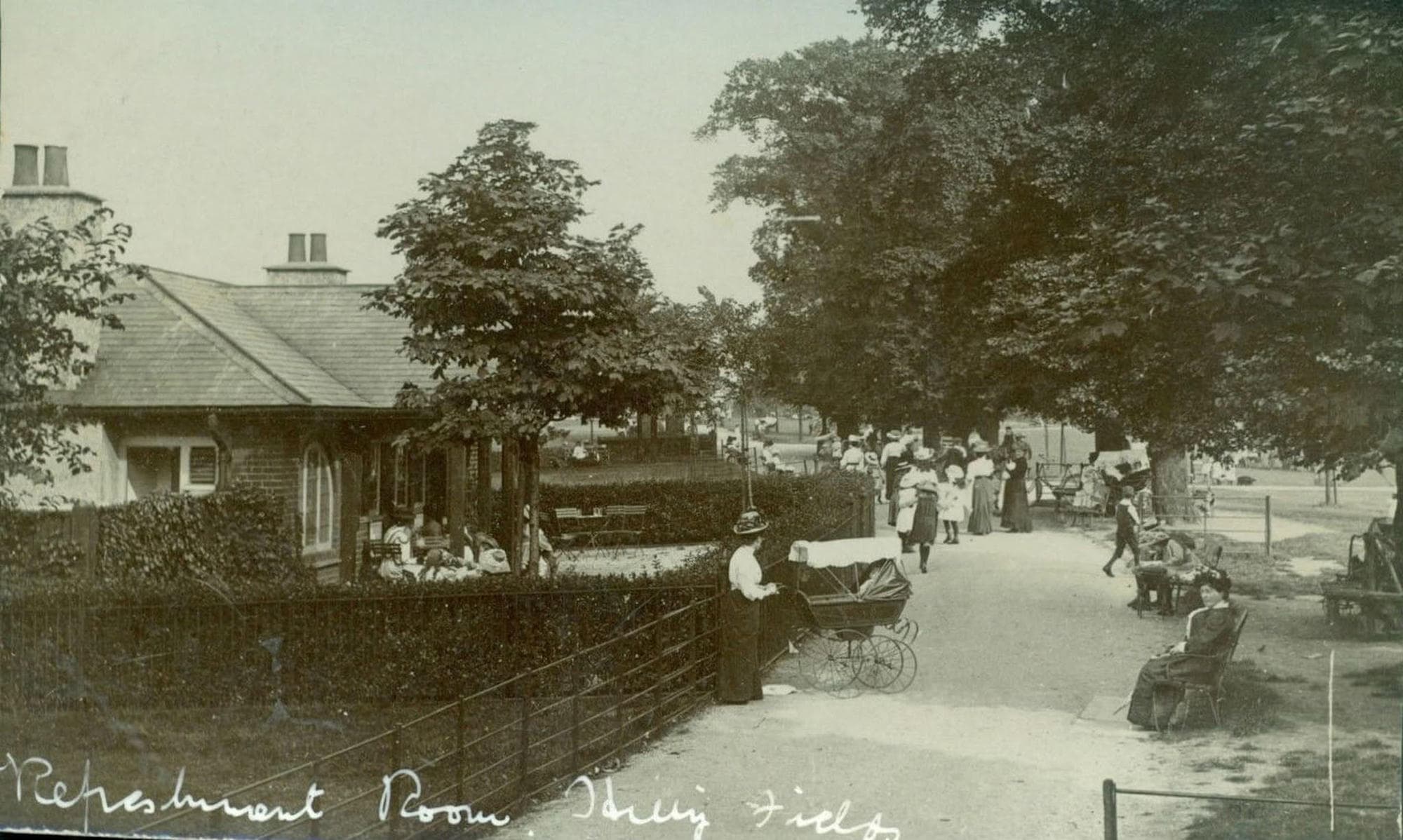 Edwardian postcard of the Refreshment Room in Hilly Fields, a single-storey building with a covered veranda beside a busy path